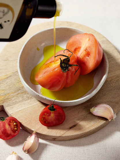 Pouring Ionian Gold olive oil onto tomatoes