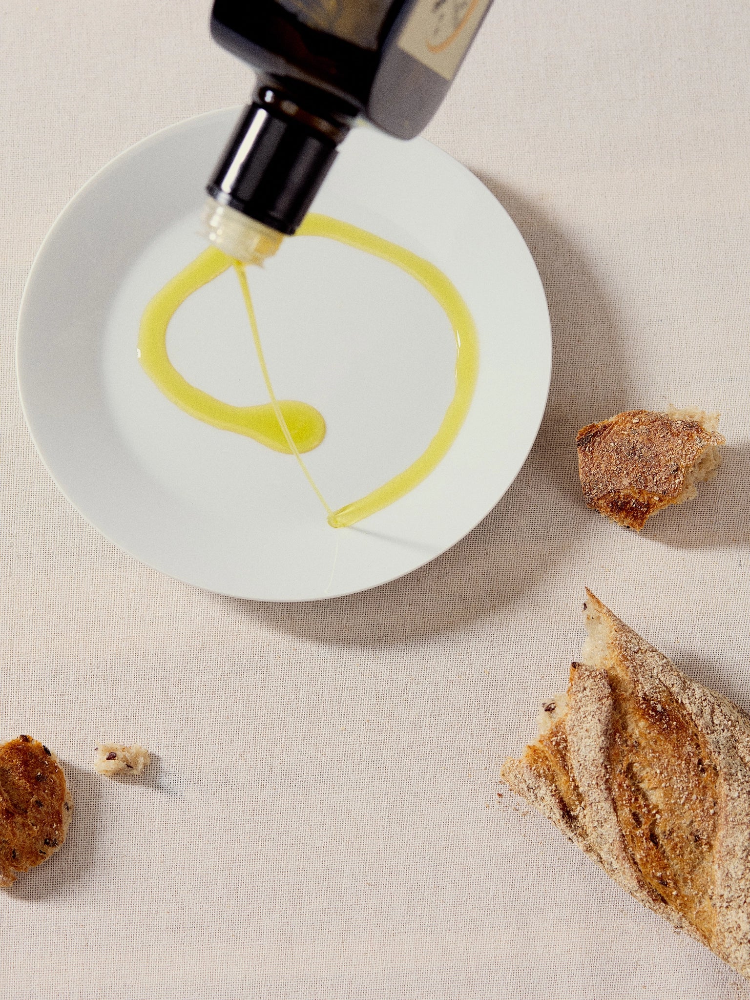 Pouring Ionian Gold black cap olive oil for dipping