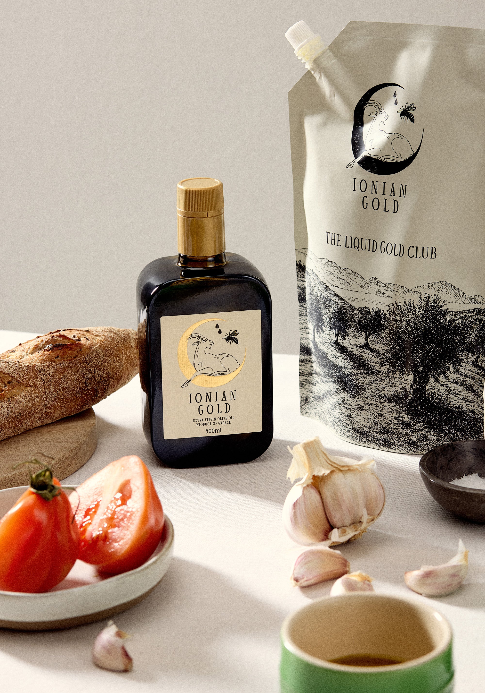 Bottle of Ionian Gold olive oil with ingredients on a table