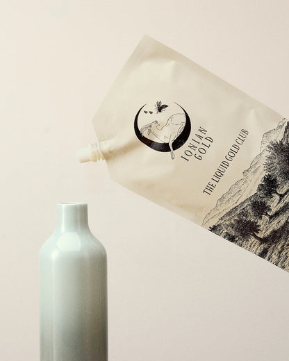 Pouring a pouch of Ionian Gold Liquid Gold Club olive oil subscription into a jar